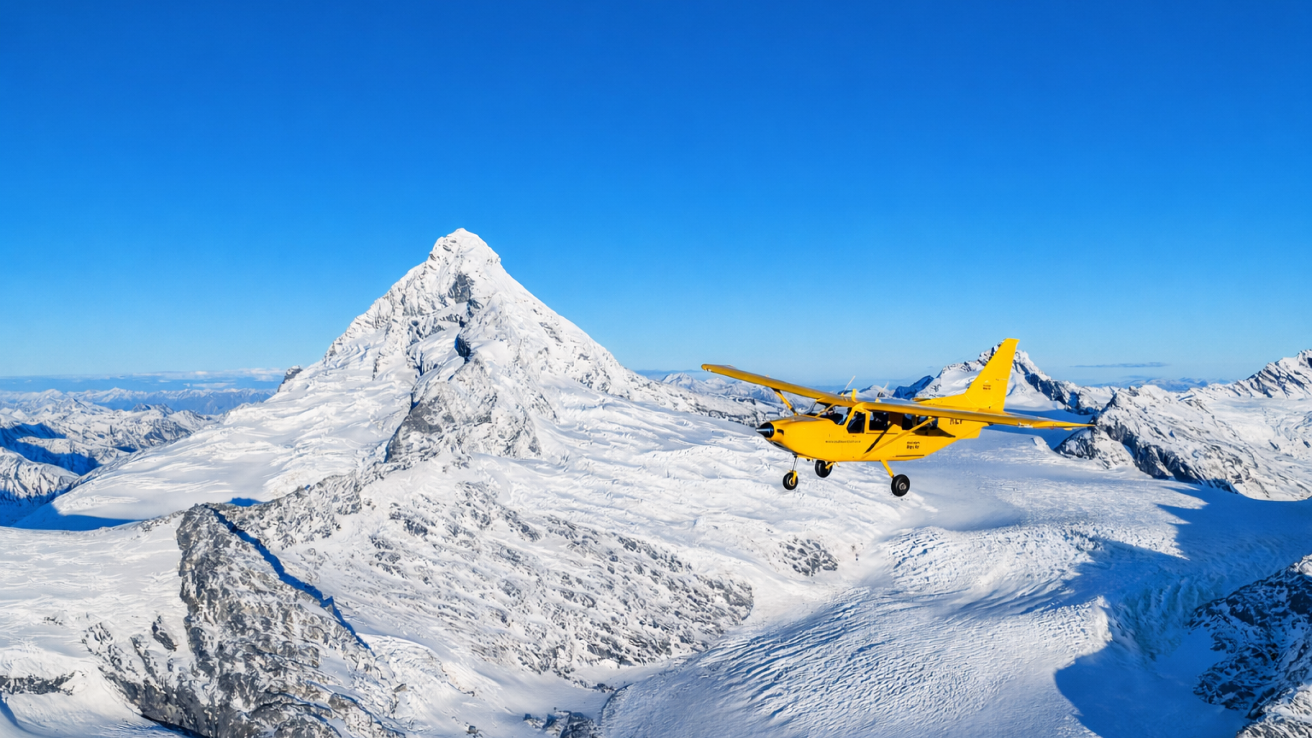 Yellow plane over snowy mountains